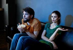 homens e mulheres em a sofá dentro uma Sombrio quarto assistindo uma Horror filme foto