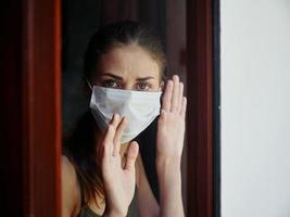 mulher dentro médico mascarar olhando Fora a janela triste expressão bloqueio foto