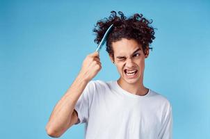 indignado cara pentear cabelo com azul pente em isolado fundo cortada Visão foto