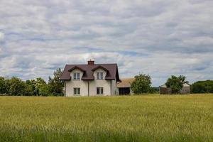 panorama com uma branco casa e uma grão campo foto