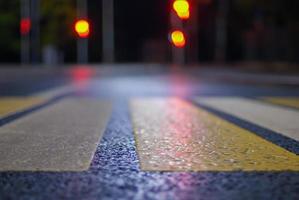 faixa de pedestre às noite rua, borrado tráfego luzes, desfocado cidade fundo foto