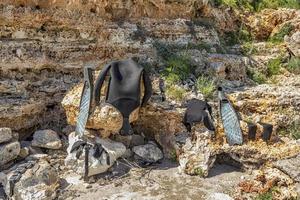 molhado partes do mergulho equipamento secagem Fora dentro a Sol em a pedras foto