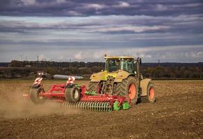 o trator prepara o terreno para semear e cultivar. conceito de agricultura e agronomia. foto