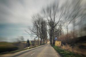 velho limitar asfalto estrada com árvores em a lado do a estrada durante uma carro passeio dentro cedo Primavera foto