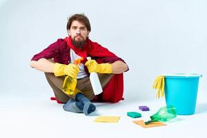 uma homem dentro uma vermelho capa de chuva sentado às casa lavando a pavimentos fornecendo Serviços trabalhos foto