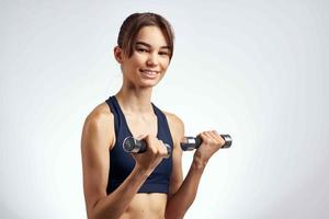 morena com uma fino figura Esportes uniforme halteres Academia foto