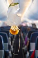 máscara de oxigênio cair do compartimento do teto no avião foto