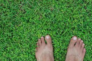 pés em verde campo do gramado para conceito fundo foto