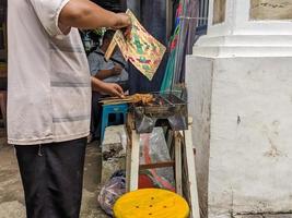 uma satay vendedor assar satay ou saciar sobre uma fogo foto