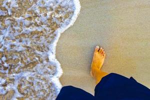 andando descalço na areia da praia pela água méxico. foto
