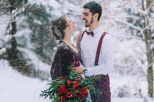 noivo em marrom e noiva em bordô nas montanhas foto