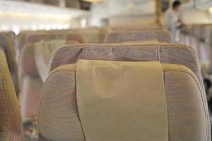 assentos de avião de passageiros vazios de cor roxa na cabine foto