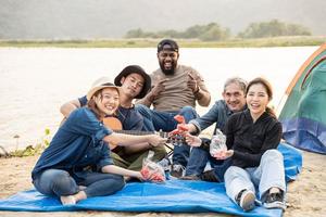 feliz amigo ter Diversão jogando guitarra e aplaudir dentro acampamento elas sorridente juntos dentro feriado em areia de praia perto acampamento barraca período de férias Tempo às pôr do sol. foto