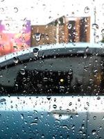 pingos de chuva espirrando em a carro janela foto