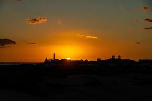 colorida pôr do sol em a espanhol ilha do vovó canaria dentro a maspalomas dunas foto