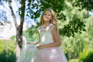 lindo adolescente menina dentro uma branco vestir dentro uma verão parque. foto