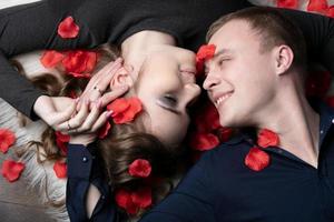 amoroso casal. homem e mulher dentro rosa pétalas. lindo jovem marido e esposa. close-up homem e mulher juntos.dia dos namorados dia. foto