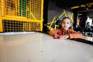 fofa pré-escolar menina jogando ar hóquei às crianças jogar Centro. foto