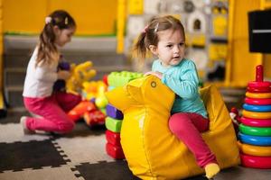 bebê menina balanços em amarelo paralon Pato às Jardim da infância. foto
