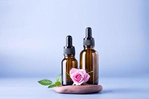 dois vidro garrafa com pipeta para uma Cosmético produtos com uma rosa em pedras foto