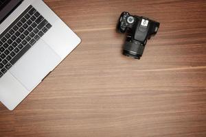 Câmera e computador portátil em de madeira mesa foto