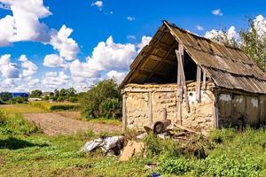 linda e velha casa de fazenda abandonada na zona rural em fundo natural foto