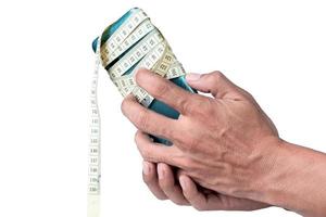 masculino mão segurando celular embrulhado com medindo fita isolado em branco fundo foto