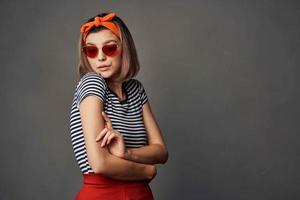 mulher com laranja curativo em dela cabeça vestindo oculos de sol posando moda luxo foto