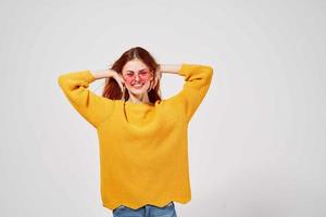 bonita mulher dentro uma amarelo suéter Penteado moda óculos foto