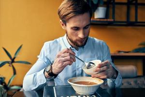 homem comendo borscht e Arroz a grega cafeteria restaurante interior o negócio finança camisa modelo foto