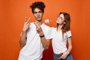 jovem casal dentro branco Camisetas e óculos Diversão moda laranja fundo foto