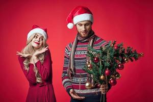 alegre jovem casal dentro Novo ano roupas feriado brinquedos decoração foto