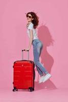 mulher turista vermelho mala de viagem Passaporte e avião bilhetes Rosa fundo foto