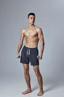 desportivo homem com bombeado acima muscular corpo ginásio halteres dentro mãos isolado fundo foto