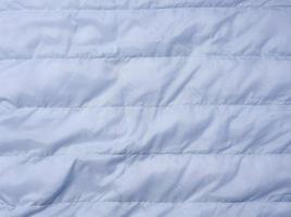 uma fragmento do azul tecido com baixa o preenchimento e costura, tecido para jaquetas e casacos foto
