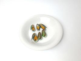 verde mexilhão em uma prato em uma branco fundo, fresco Novo zelândia mexilhão ou perna canalículo em uma branco fundo. isolado verde mexilhões. foto