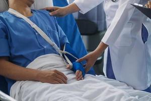 homem com quebrado braço dentro fundida deitado em cama dentro hospital. a emergência Centro tratamento é gesso e trava com Funda para uma mais distante cura dentro a ortopédico clínica. paciente dor a partir de acidente ferida. foto