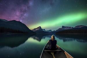 viajante mulher sentado em canoa com aurora boreal sobre espírito ilha dentro maligno lago às jaspe nacional parque, alberta, Canadá foto