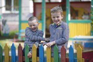 Jardim da infância em a rua.dois pequeno amigos estão jogando. Jardim da infância Rapazes dentro a Parque infantil foto