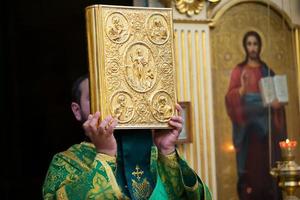 Palma domingo.sacerdote com uma Bíblia. foto