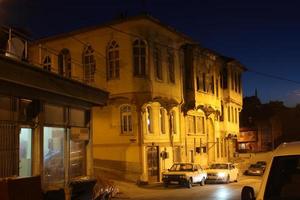 velho turco casa iluminado com rua luminária às noite foto