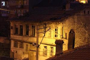 velho turco casa iluminado com rua luminária às noite foto