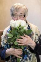 idosos mulher com uma ramalhete do rosas. foto