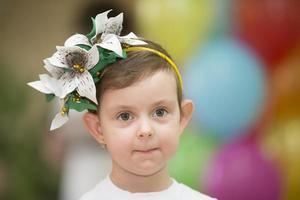retrato do uma engraçado garota. pequeno engraçado menina com orelhas caídas orelhas e uma floral guirlanda em dela cabeça. foto