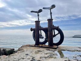 casal monociclos às a mar lado foto