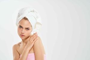 mulher com uma toalha em dela cabeça algodão almofada limpar \ limpo pele dermatologia luz fundo foto