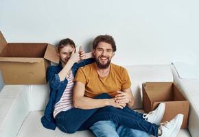 homem e mulher em branco sofá interior cartão caixas estilo de vida foto