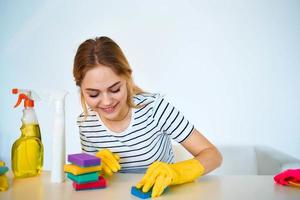 a limpeza senhora senta às a mesa lavando suprimentos limpeza trabalhos serviço foto