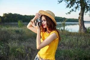 mulher fotógrafo olhando para dentro Câmera lente vermelho lábios chapéu fresco ar panorama foto