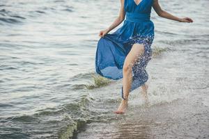 mulher de vestido azul na água foto